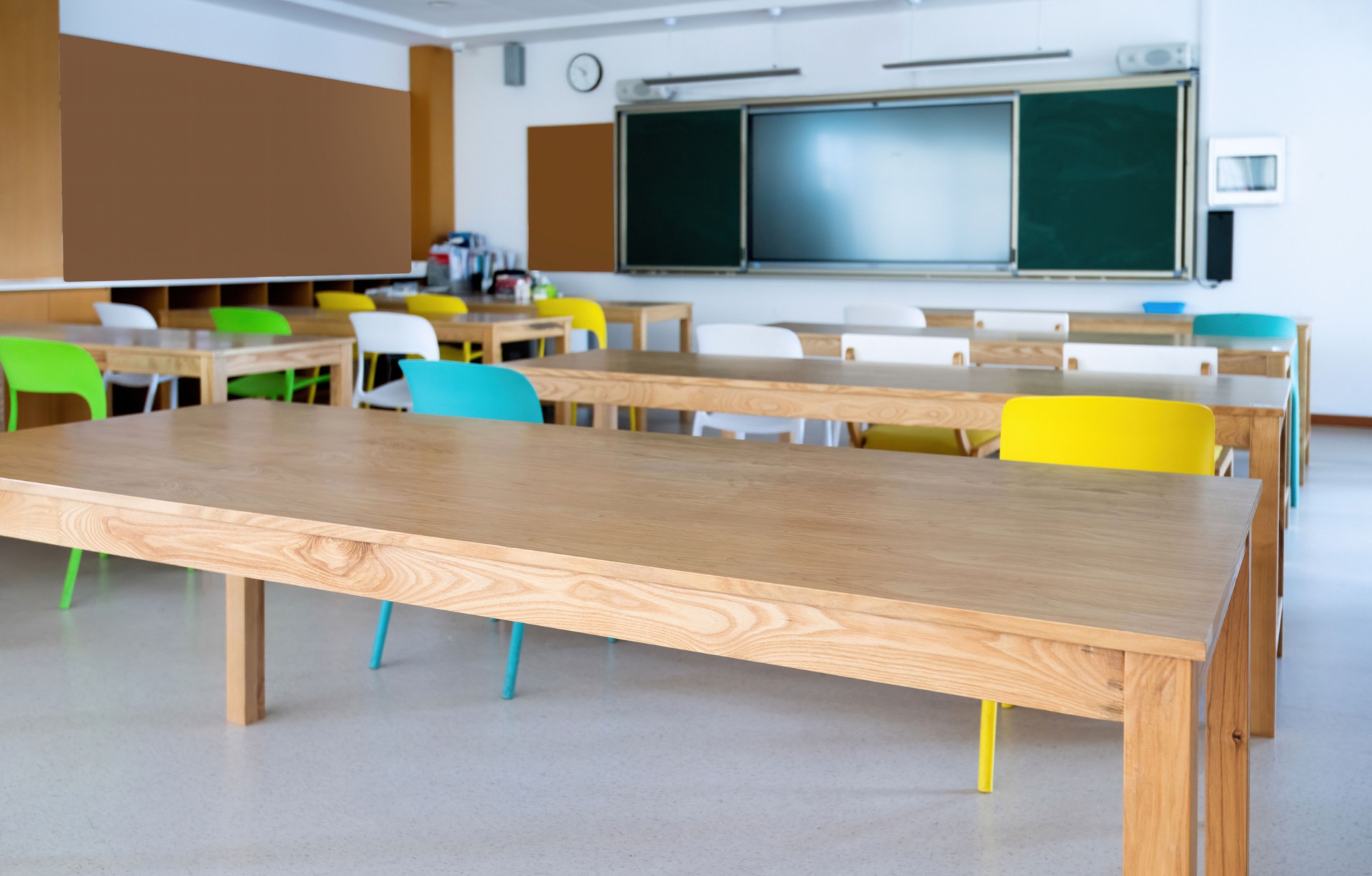 An empty classroom with long wooden desk