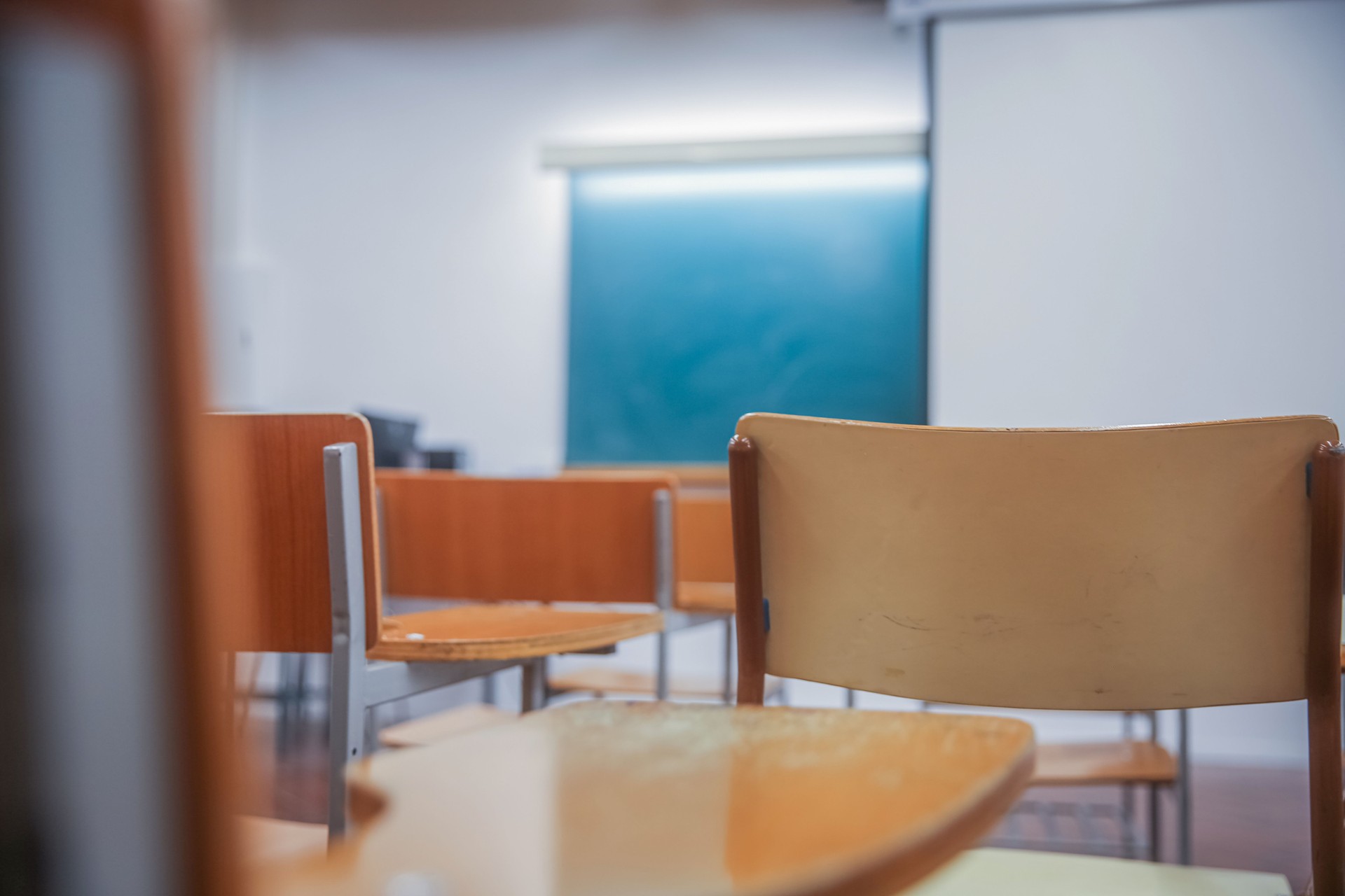 Modern classroom with empty chairs, projector, and chalkboard, an old classic style with no evolution, the educational spaces stuck in the past